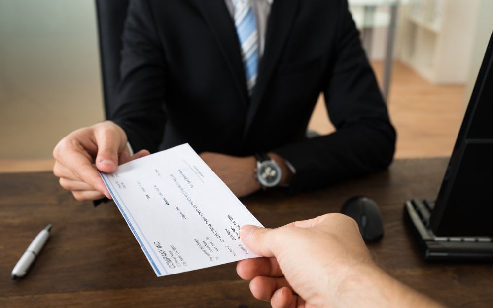attorney-handing-a-client-a-check-from-a-personal-injury-settlement-in-colorado_orig-1000x625-1000x625